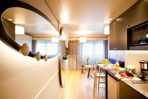 a kitchen with a counter and a dining room at Aparthotel Adagio access München City Olympiapark in Munich