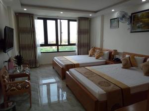 Una habitación de hotel con dos camas y un televisor. en Royal Hotel, en Hai Phong