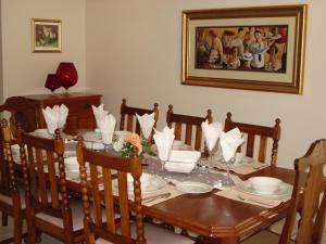 a dining room with a table with chairs and a painting at Sonyador Guesthouse in Boksburg