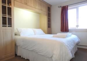 a bedroom with a large white bed with a window at Century House in Gosport