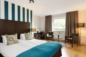 um quarto de hotel com uma cama e uma secretária em ProfilHotels Hotel Garden em Malmo