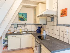 una cocina con armarios blancos y fregadero en Holiday home in Bestwig with private garden, en Bestwig