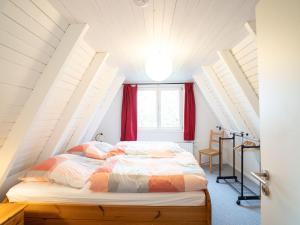 a bed in a attic room with red curtains at Holiday home in Bestwig with private garden in Bestwig