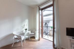un soggiorno con tavolo e sedie e un balcone di Quattro Canti Charming Flat a Palermo