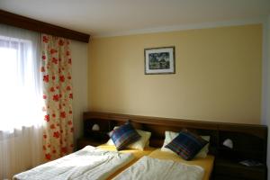 a hotel room with two beds and a window at Haus Zillertal am Achensee in Maurach