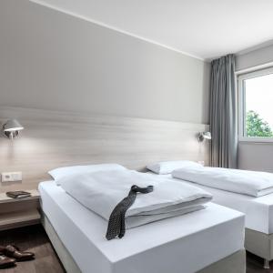 two beds in a hotel room with a penguin on them at Serways Hotel Lüneburger Heide West in Behringen