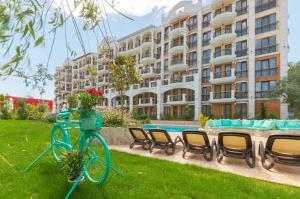 een fiets geparkeerd in het gras voor een gebouw bij Harmony Suites Grand Resort in Sunny Beach