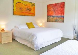 a bedroom with two beds and paintings on the wall at The Gallery in Gosport