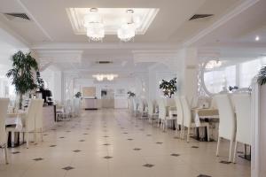 アナパにあるAlean Family Resort & SPA Doville 5* Ultra All Inclusiveのダイニングルーム(白いテーブル、白い椅子付)