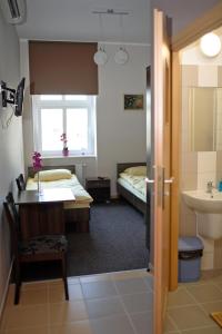 Habitación con 2 camas, lavabo y baño. en Noclegi Gemini Dom, en Elbląg