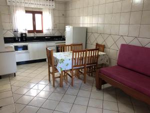 a kitchen with a table and chairs and a couch at Pousada Açoriana in Florianópolis