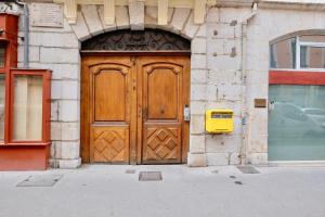 uma grande porta de madeira num edifício com uma caixa de correio amarela em Honorê - Suite Vaubecour em Lyon