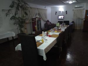 a long dining room with a long table and chairs at Kuku Royal Lodge in Ndola