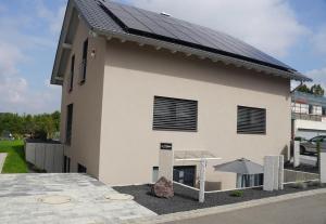 a large white building with a solar roof at Apartment Seven in Ringsheim