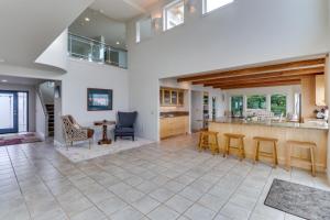 a large kitchen with a counter and chairs and tables at Camano Island Waterfront Modern Splendor in Lona Beach
