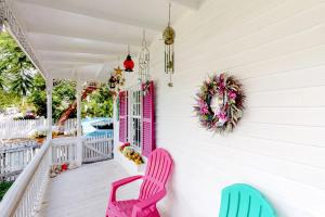 a porch with pink and blue chairs and a wreath at Gingerbread in Key West