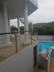 a balcony with a swimming pool on top of a building at Knysna Pearl View Guest House in Knysna