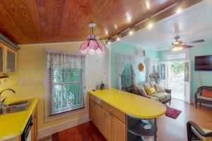 a kitchen with a yellow counter top and a living room at Gingerbread in Key West
