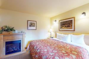 レブンワースにあるAspen Suites 506: The Nestのベッドと暖炉付きのホテルルーム