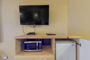 a desk with a microwave and a tv on a wall at Aspen Suites 506: The Nest in Leavenworth