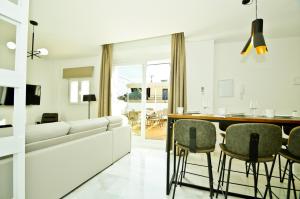 een woonkamer met een witte bank en stoelen bij NineSuites in Sevilla
