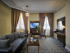 a living room with a couch and a table at Grandezza Hotel Luxury Palace in Brno