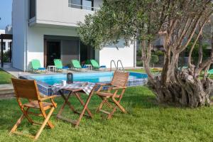 a table and chairs next to a swimming pool at Filerimos Garden Villa in Ialyssos +19 photos