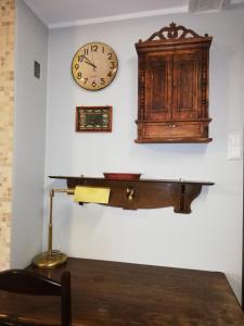 um relógio e um armário de madeira numa parede em Apartament V Piętro em Sopot