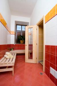 La salle de bains est pourvue d'un banc et de carreaux rouges et blancs. dans l'établissement YELLOW STREET APARTMENT, à Rokytnice nad Jizerou
