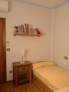 1 dormitorio con cama y estante con libros en -1-Igual que tu casa, garaje gratis, en el centro, en Úbeda