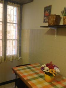 a room with a table with a vase of flowers on it at Vista mare vecchia città in Menton