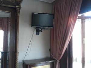 uma televisão de ecrã plano no canto de um quarto em Hotel Begoña em Gijón