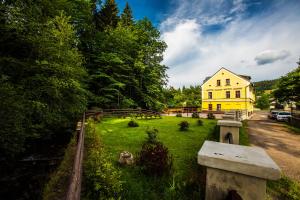 une maison jaune au milieu d'une cour verdoyante dans l'établissement YELLOW STREET APARTMENT, à Rokytnice nad Jizerou