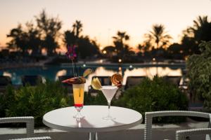 two cocktails sitting on a table next to a pool at Alexandre Grand Teguise Playa in Costa Teguise