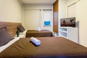 ウルアウにあるDream Away Uruaú Beach Residencesのベッド2台、薄型テレビが備わるホテルルームです。