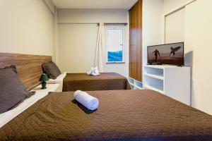 a hotel room with two beds and a flat screen tv at Dream Away Uruaú Beach Residences in Uruau +48 photos