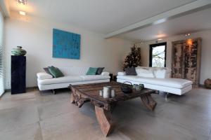 a living room with two white couches and a coffee table at ARVAK HEYD (DURBUY) in Heyd