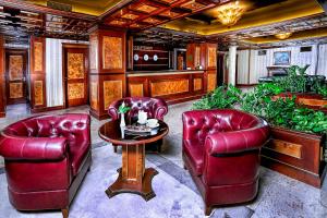 uma sala de estar com cadeiras de couro vermelho e uma mesa em Casa Boyana Boutique Hotel em Sófia