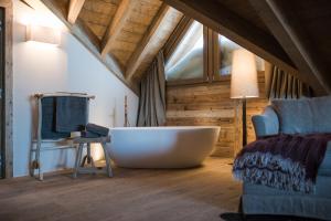 a large bath tub in a room with a couch at Sunny Valley Mountain Lodge in Bormio