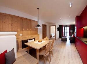 Zin Senfter Residence في سان كانديدو: مطبخ وغرفة معيشة مع طاولة خشبية وغرفة طعام