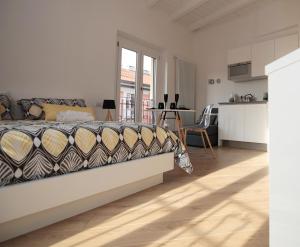 a white bedroom with a bed and a kitchen at P&D APARTMENTS NAVIGLI VIA CASALE in Milan