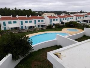 arial view of a villa with a swimming pool and houses at Alvor Village By The Sea in Alvor