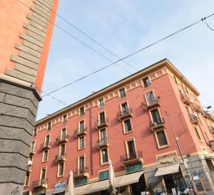ein großes rotes Gebäude an der Straßenseite in der Unterkunft P&D APARTMENTS NAVIGLI VIA CASALE in Mailand