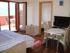 a bedroom with a bed and a desk with a television at Apartments Josip in Pinezici