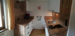 eine kleine Küche mit Holzschränken und einem Waschbecken in der Unterkunft Haus Jägerheim in Nauders