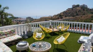 a patio with chairs and tables on a balcony at Finca La Vida Loca B&B - Adults Only in Benalmádena