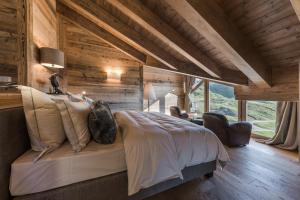 una camera con un letto in una stanza con pareti in legno di Sunny Valley Mountain Lodge a Bormio