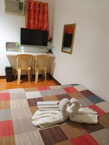a room with a bed with a towel on the floor at Park Vil-la Apartelle in Manila