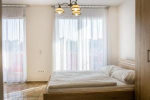 a bedroom with a bed and a large window at Luxury Apartment Hotel Siófok in Siófok