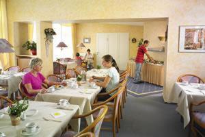 un grupo de personas sentadas en mesas en un restaurante en Thöles Gästehaus garni, en Hoya